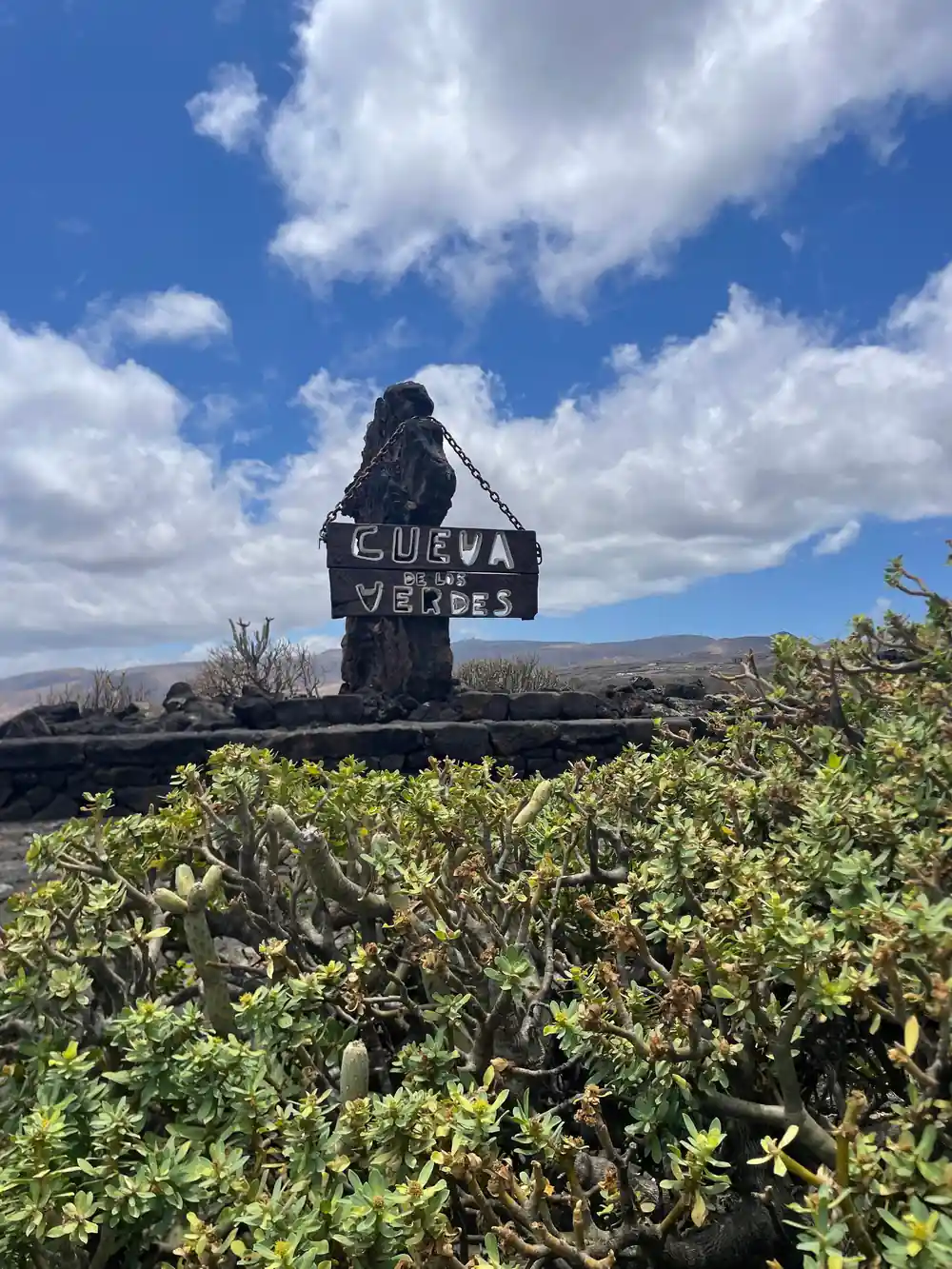Black metal rock formation sign with vegetation in foreground
