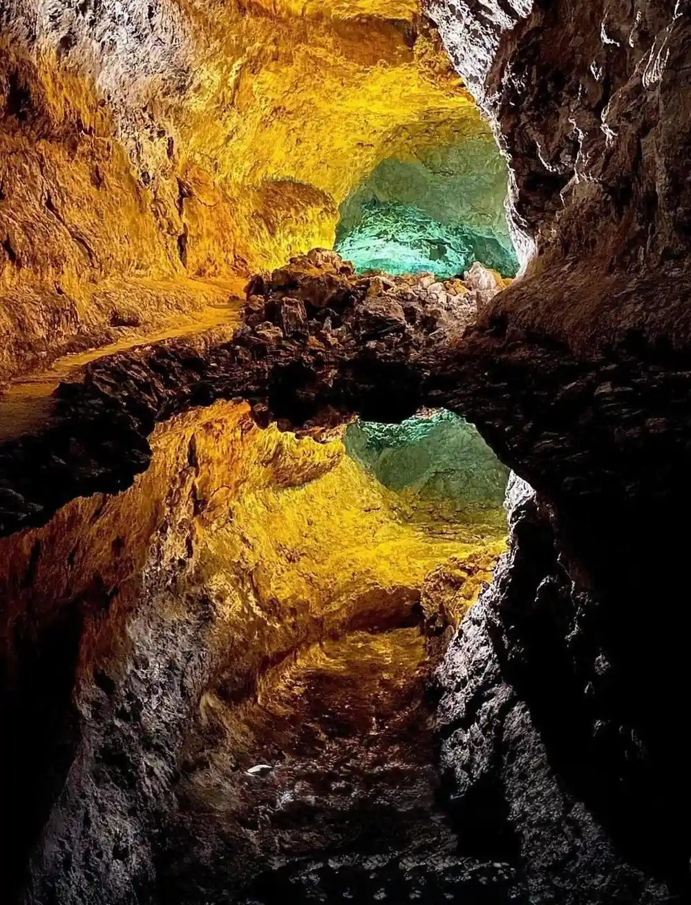 Cave interior with yellow rock and turquoise pool