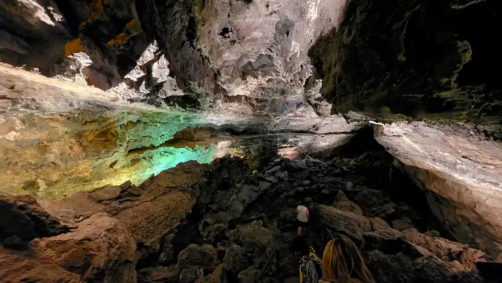 Cave tunnel with green water and rock formations