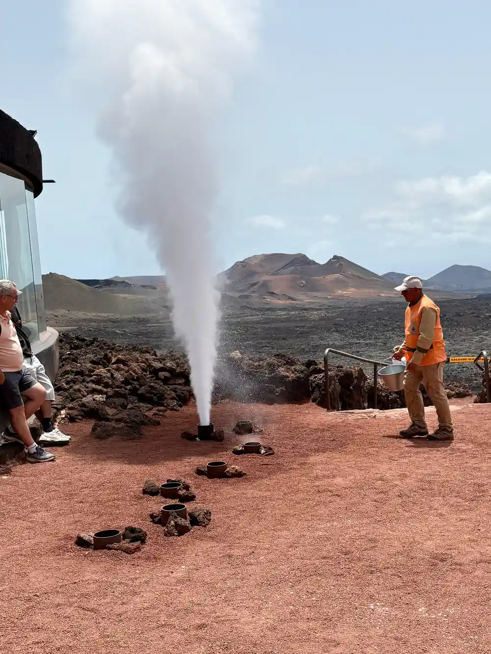 Geyser erupting water column in volcanic landscape