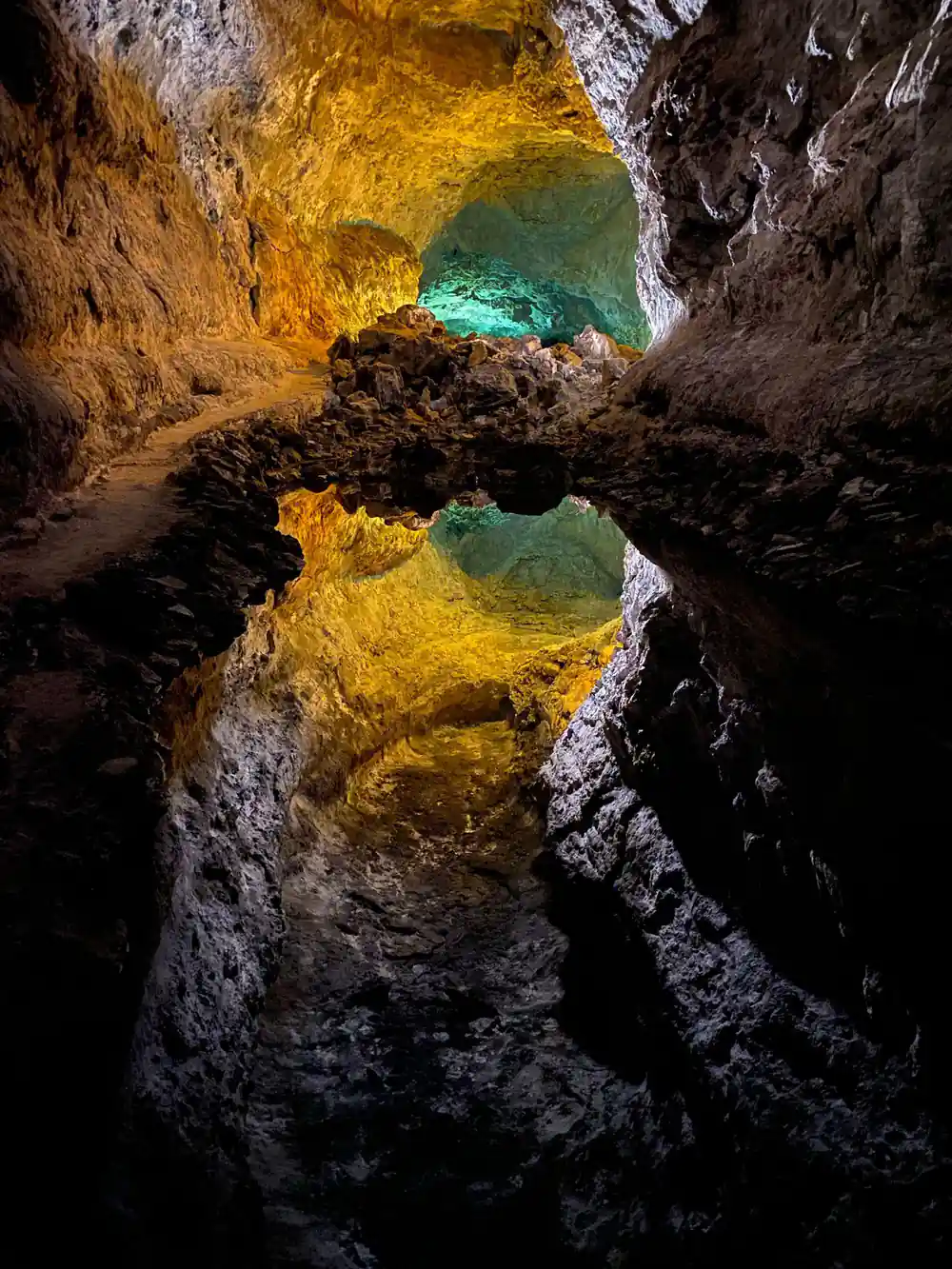 Golden cave ceiling with turquoise pool and rock formations