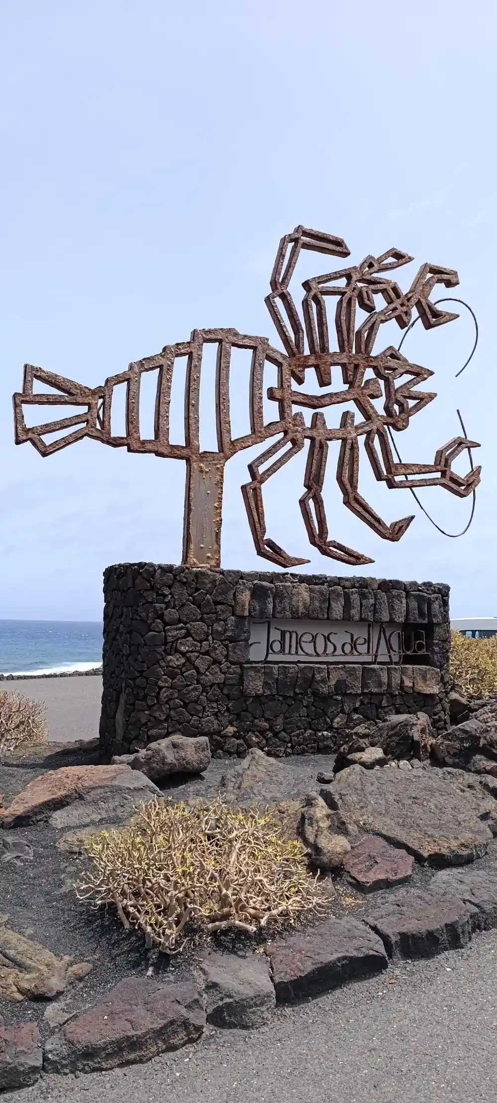 Metal sculpture of fish with tentacles on black stone base