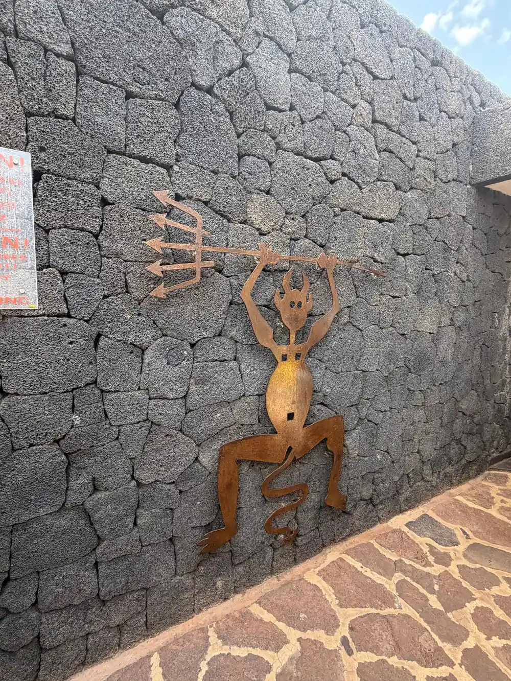 Terracotta-colored relief figure carved into dark stone wall