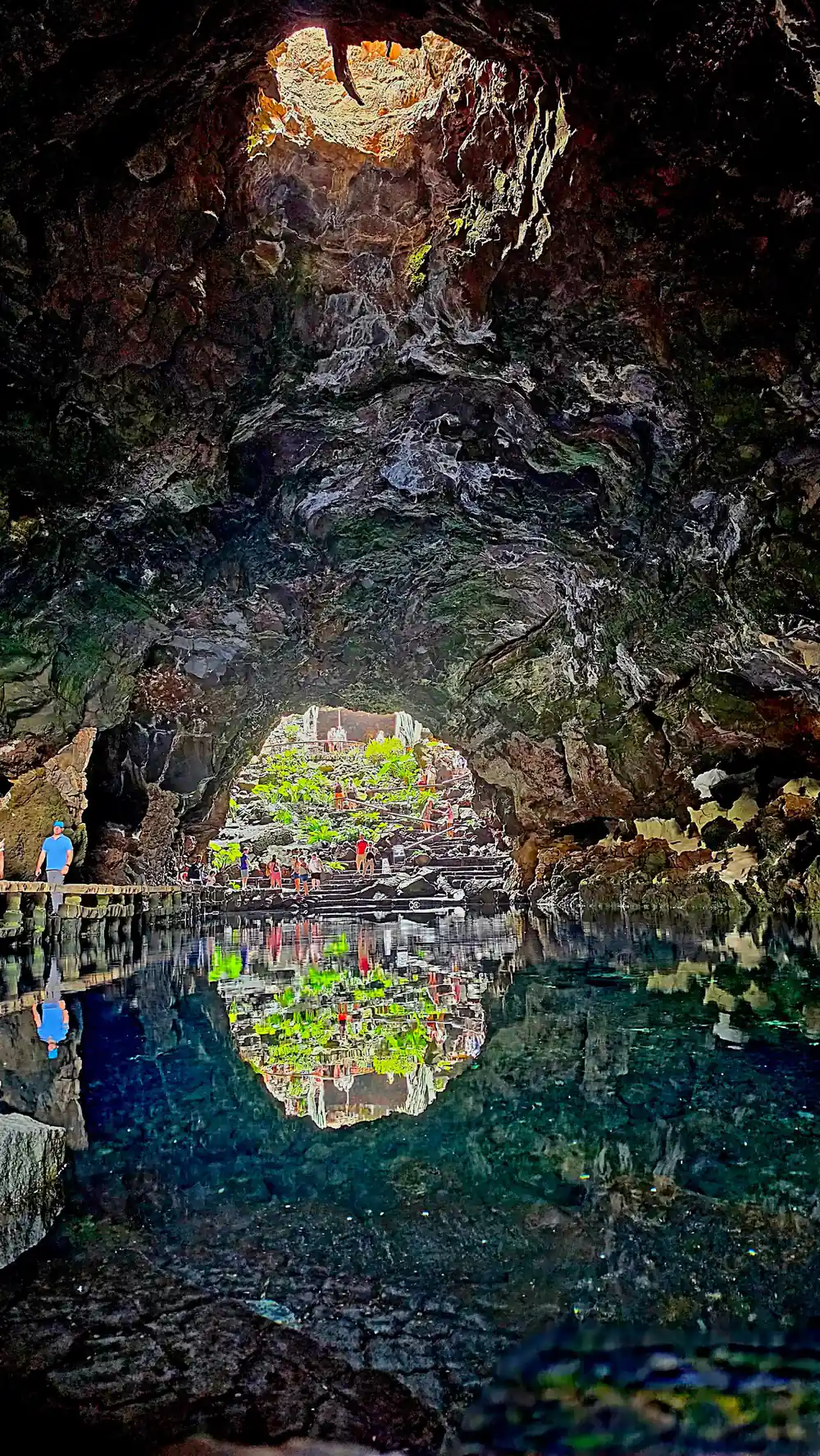 Underground cave with mirror pool reflecting rocky ceiling