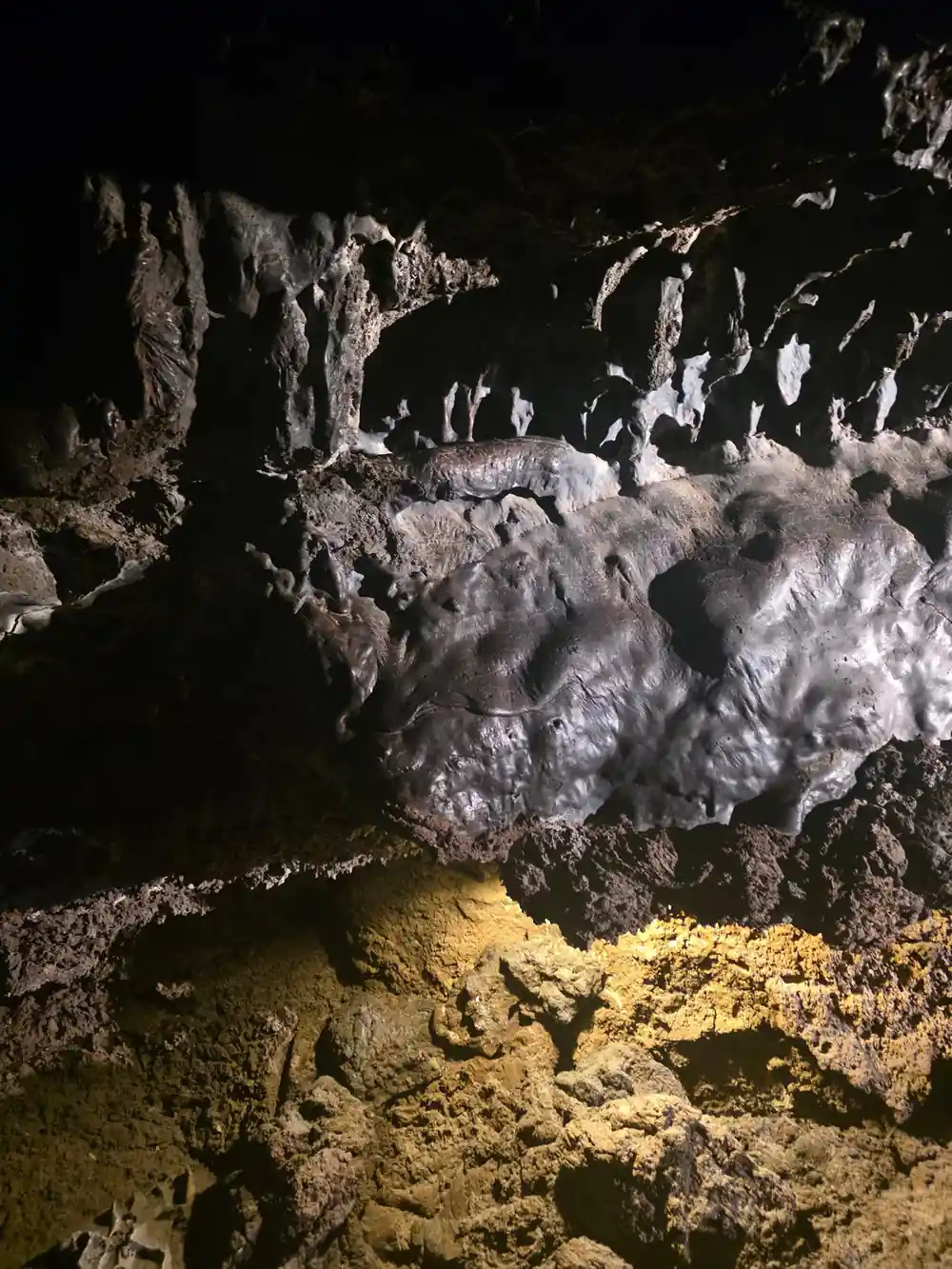Underground cavern with white mineral formations and yellow deposits