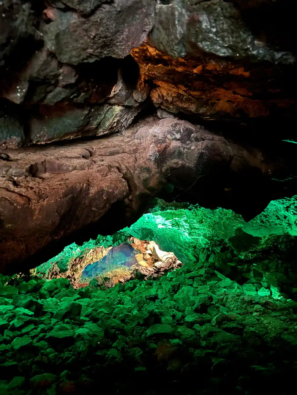 Underground cenote with bright green algae and rocky formations