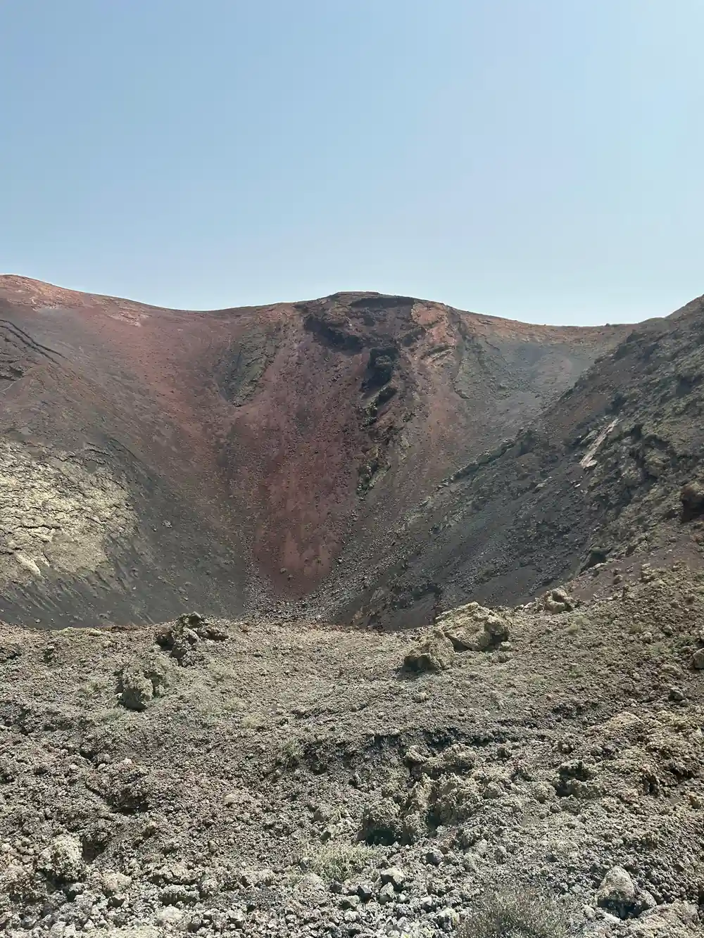 Volcanic crater cone with reddish-brown layered rock formation