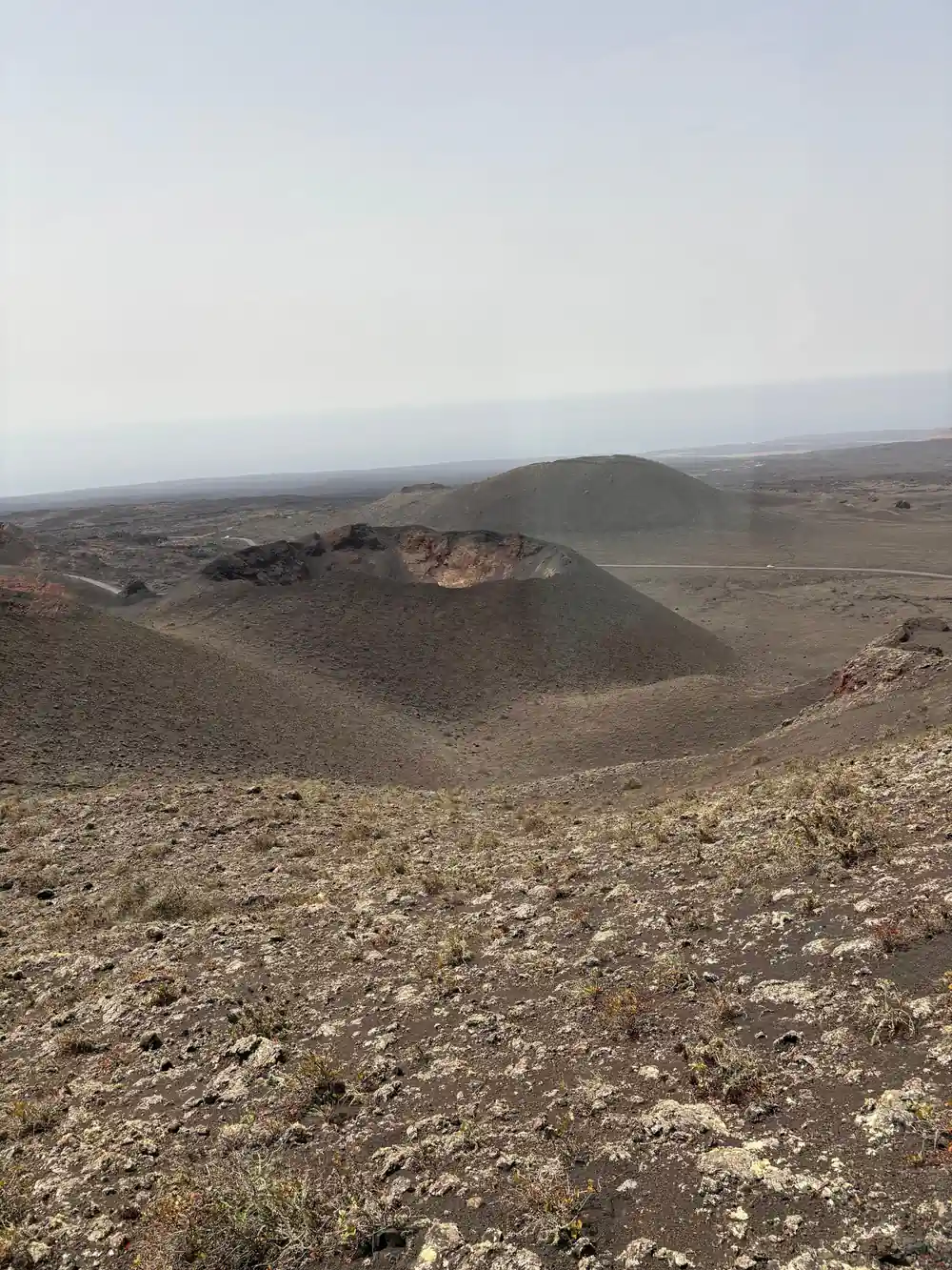 Volcanic crater with dark cinder cone in desert
