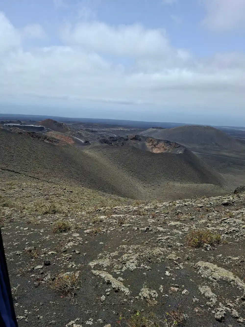 Volcanic crater landscape with scattered cones and ocean horizon