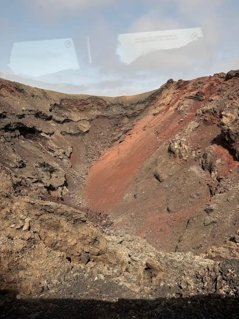 Volcanic crater with red and brown layered rock formations