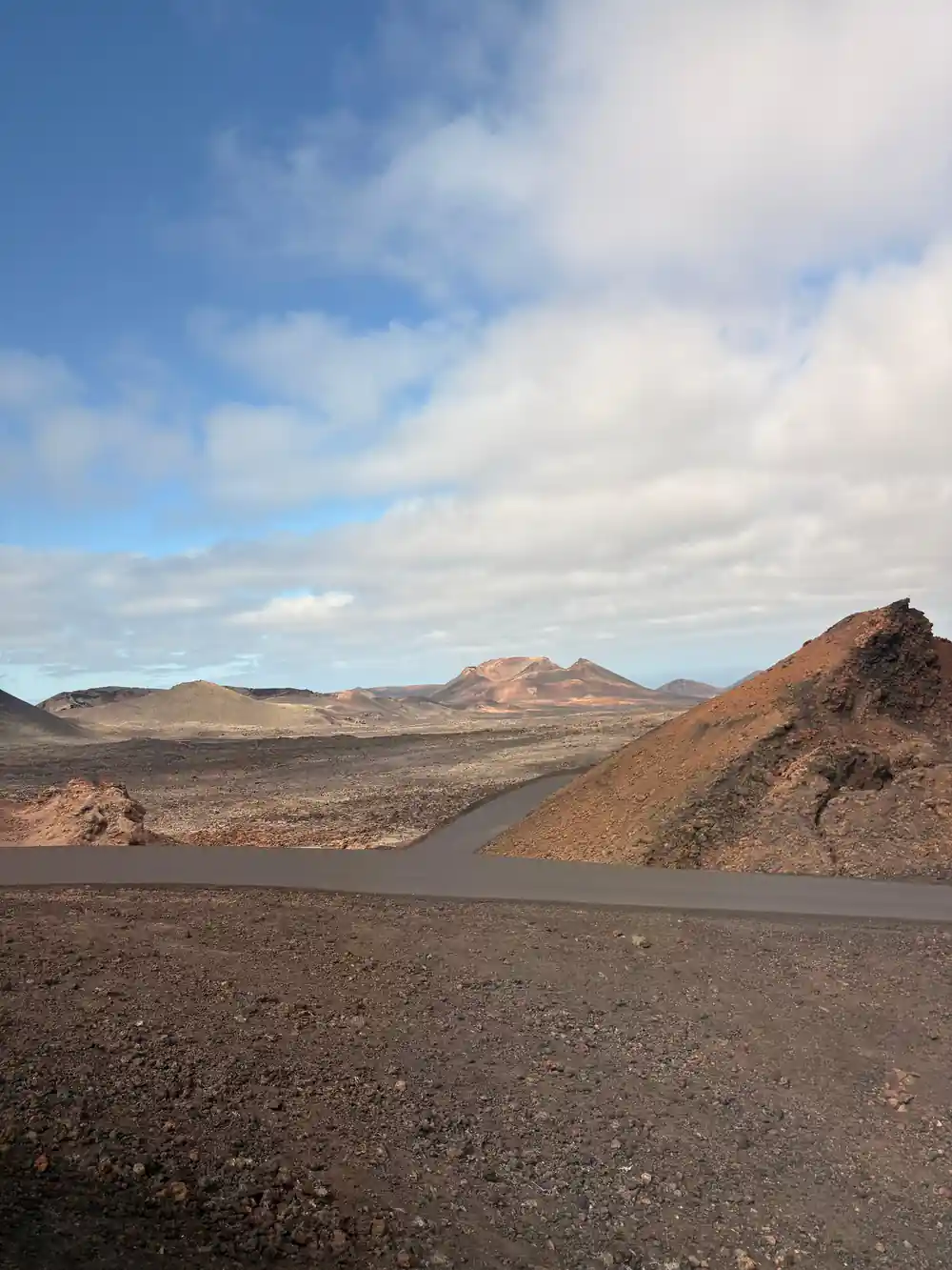 Volcanic landscape with dark lava fields and distant peaks