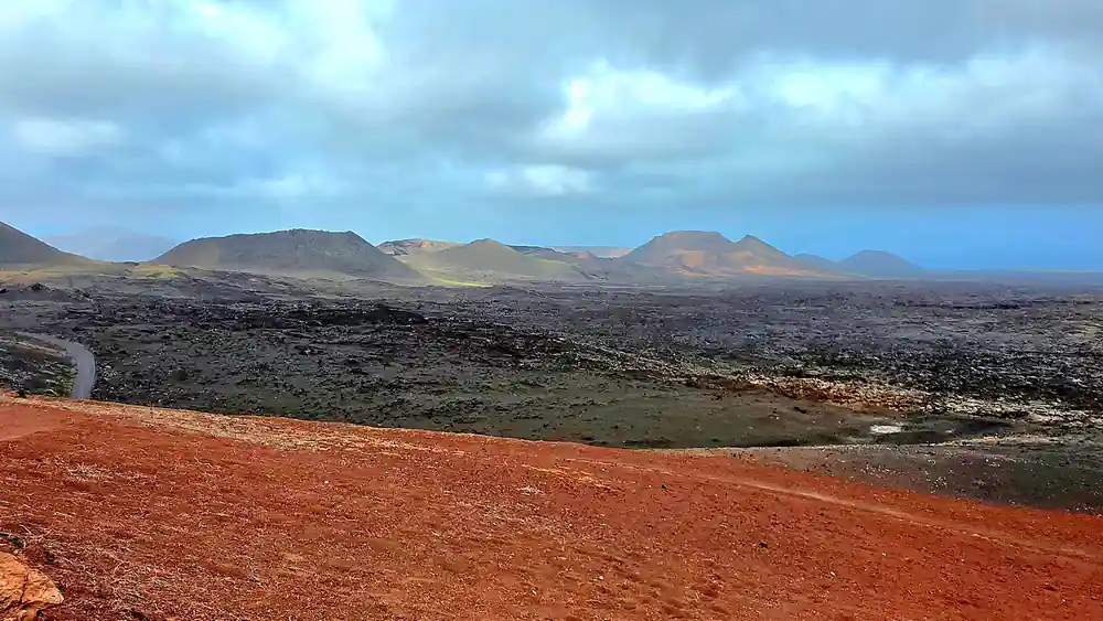 Volcanic landscape with dark lava fields and mountains