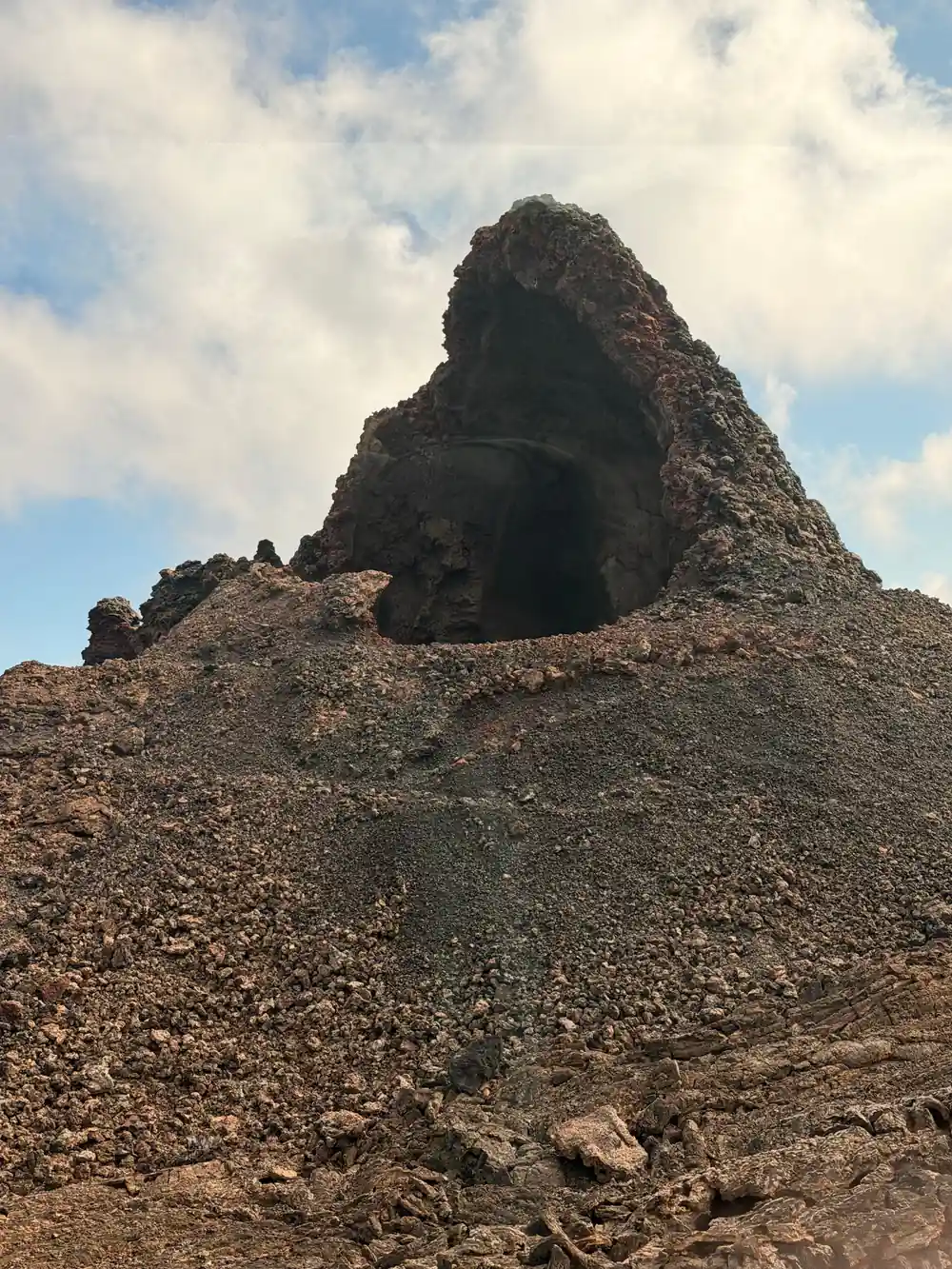 Volcanic rock cone with dark central crater opening