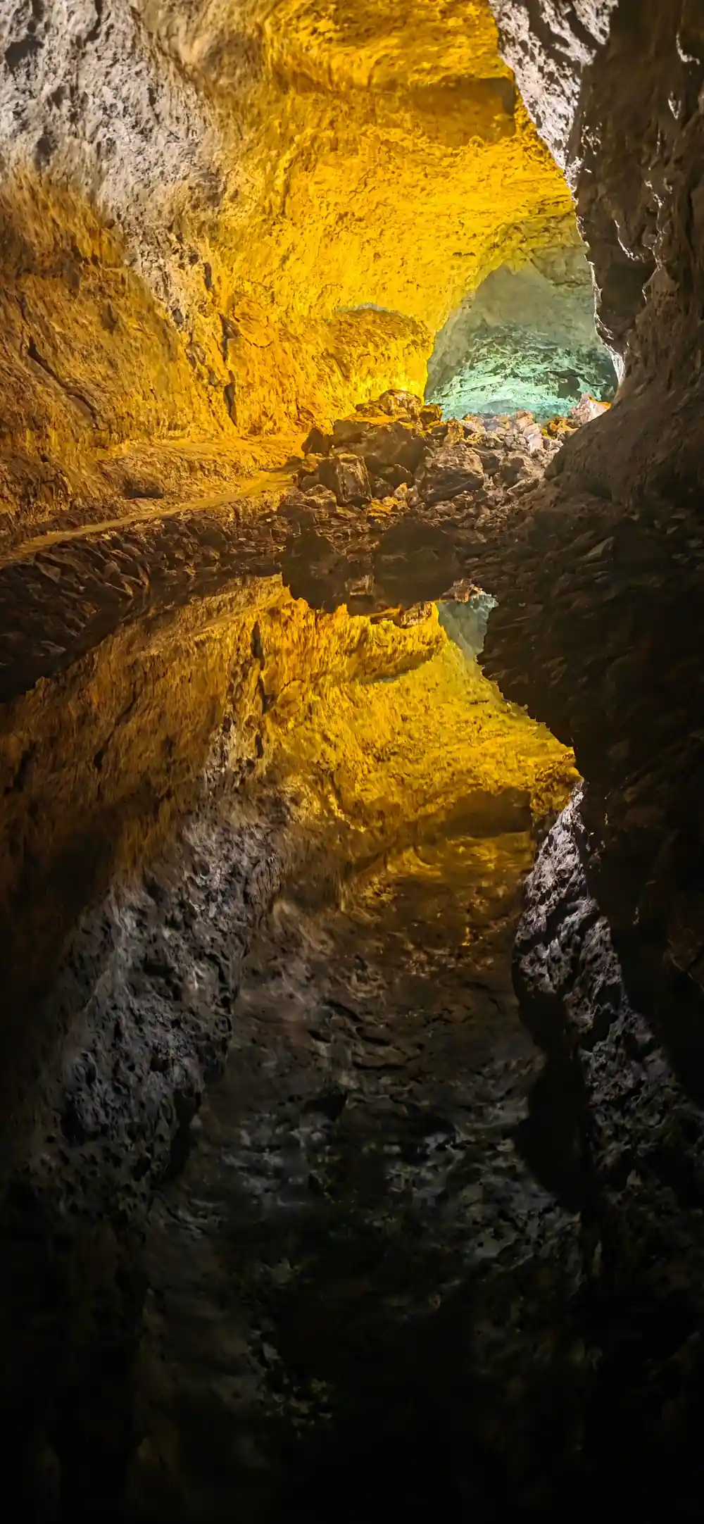 Yellow cave opening framing turquoise pool below